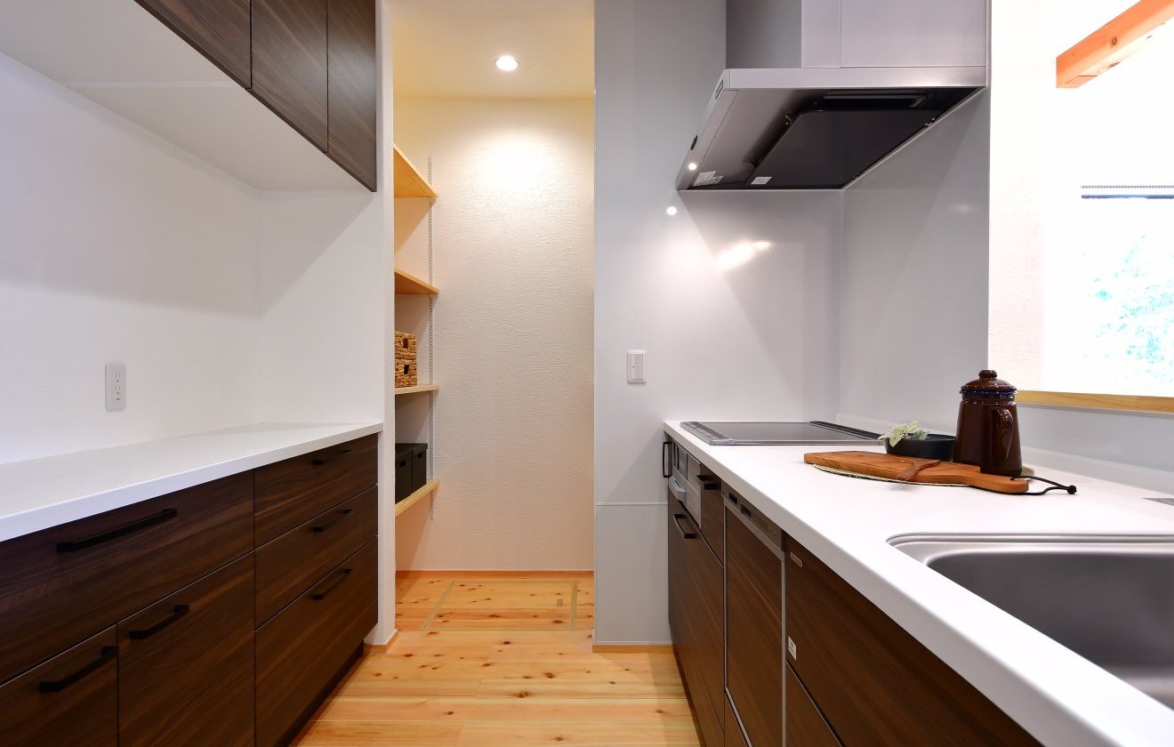 キッチンのすぐ横には、食品や日用品をたっぷり収納できる便利なパントリーを配置。収納も豊富で、生活感を抑えながらスッキリとした空間を保てます。腰壁越しにリビングを見渡せるため、料理中でも家族の様子が自然と目に入り、コミュニケーションもスムーズに。“使いやすさ”と“心地よさ”を両立したキッチンです。