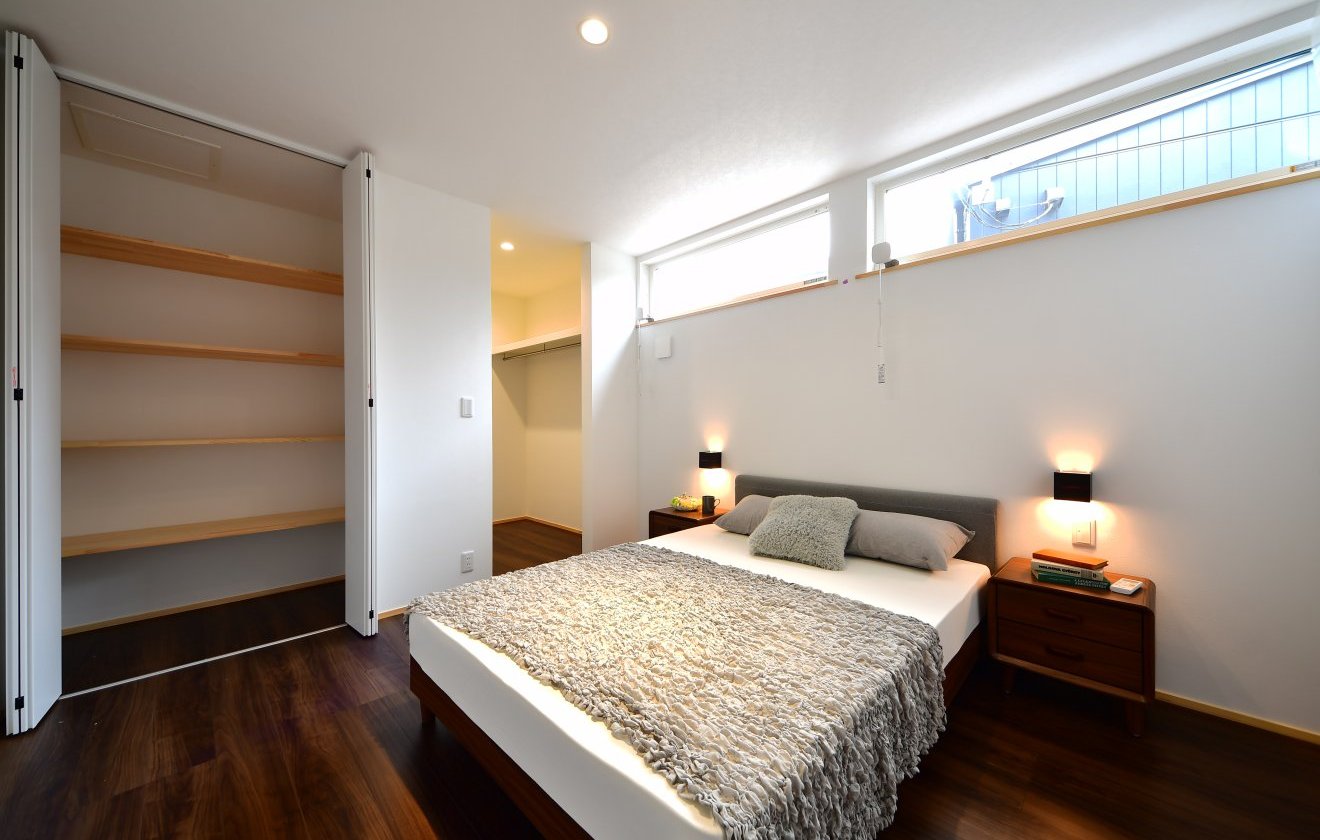 高窓からやわらかな光が差し込みことで、上質な雰囲気をつくる主寝室。奥にはゆとりあるウォークインクローゼットを備え、衣類をたっぷり収納できます。さらに、入口横には可動棚付きの物入も配置し、バッグや小物、寝室まわりの生活用品までスマートに整理。“見せない収納”がしっかり整うことで、心からくつろげる空間に仕上がっています。